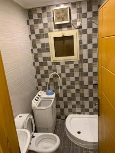 a small bathroom with a toilet and a sink at شقة للإيجار شهري اسبوعي يومي تبعد عن الحرم المكي 4 كيلو-قريبة من قطار الحرمين قريبة من محطة باصات رئيسية in Aţ Ţunḑubāwī
