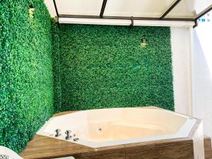 a bathroom with a green wall with a bath tub at Lujosa y exclusiva casa en Salinas! Cerca de todo in Salinas +21 photos