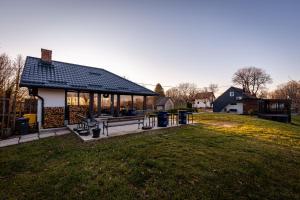 a house with a pavilion in a grass field at Kuća za odmor Natur in Brežane Lekeničke