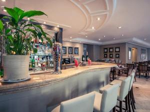 a bar in a restaurant with white chairs at Pinheiros Luxuoso Flat em hotel 4 star in São Paulo