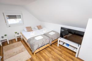 a small bedroom with a bed and a flat screen tv at Kuća za odmor Natur in Brežane Lekeničke
