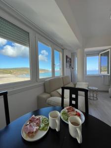 a living room with two plates of food on a table at Marusía apartamento in Malpica