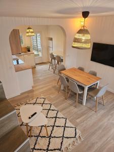 Una sala de estar con una mesa y sillas de madera. en Maison cosy avec jardin, Disney, en Favières