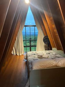 a bedroom with a bed and a large window at Chalé Pôr do Sol Contenda in Contenda