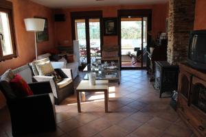 a living room with couches and a tv and a table at Casa El Acebo in Muros de Nalón