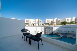 a balcony with two chairs and a swimming pool at Sky Star Hotel free shuttle to Hurghada City Center in Hurghada