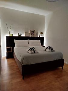 a bedroom with a large bed with two shoes on it at Le Petit Nottolini in Lucca