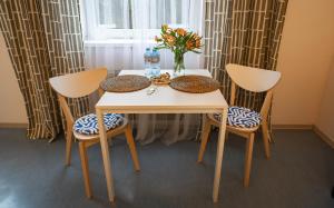 a table with two chairs and a vase of flowers at Apartament Odertal in Cedynia