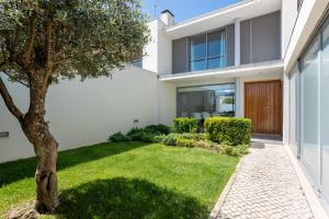 an exterior view of a house with a green yard at Villa Oliveira in Sesimbra