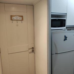 Estilo Mar في مار ديل بلاتا: باب مطبخ مع مايكرويف وثلاجة