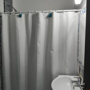 Estilo Mar في مار ديل بلاتا: حمام مع ستارة دش بيضاء ومغسلة