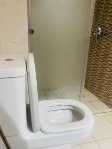 a white toilet in a bathroom with a shower at sonu guest house in Dakar +20 photos