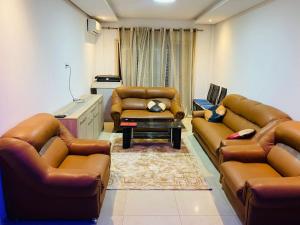 a living room with leather couches and a table at sonu guest house in Dakar