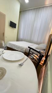 a room with two beds and a table with a fork on it at RUNO inn Hotel in Baku