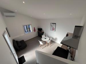 a white living room with a couch and a table at Le Gîte des Louis in Chanos-Curson