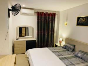 a bedroom with a bed and a sink and a mirror at sonu guest house in Dakar