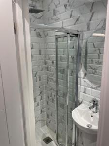 Un baño blanco con ducha y lavabo. en 5 Bedroom Modern and Spacious House in London, en Fairlop Station 83 fotos más