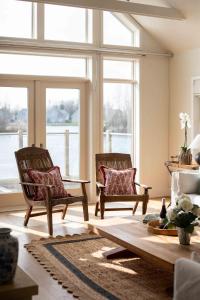 two chairs and a table in a living room with windows at Summer Lake in South Cerney