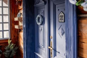 a blue door of a house with a sign on it at Domek Stu Wiosen - Beskid Niski in Klimkówka