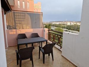 a balcony with a table and chairs on a balcony at résidence AP 2 Saidia in Saïdia +2 photos