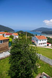 a view of a town with houses and a tree at Beachfront Surf & Holiday House, Charming & Quiet in Villarrube