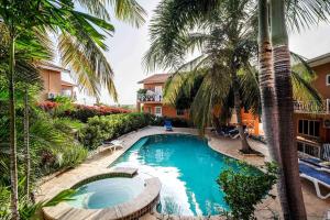an image of a swimming pool with palm trees at Botanical Apartment Central Boho style 2 pools in Willemstad