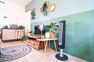 a living room with a tv on a wall at Botanical Apartment Central Boho style 2 pools in Willemstad