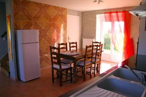 a kitchen with a table and chairs and a refrigerator at Gite FABYPHIL in Youx