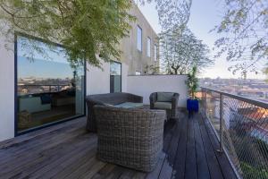 ein Balkon mit Korbstühlen und einem Tisch auf einer Terrasse in der Unterkunft Local 167 - Oporto View House in Vila Nova de Gaia