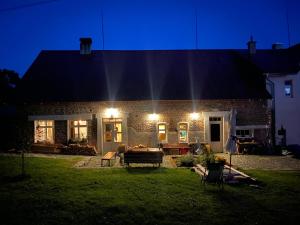 a brick house with lights in the yard at night at Apartmány Malý Princ in Horní Blatná