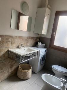 une salle de bain avec un lavabo et une machine à laver dans l'établissement Elena's Home piano terzo, à Chioggia