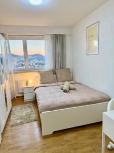 a bedroom with a bed with a stuffed animal on it at Skyline Retreat Jedes Zimmer mit TV in Baden