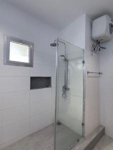 La salle de bains est pourvue d'une douche en verre et d'une fenêtre. dans l'établissement Luxury flat Sicap, à Dakar