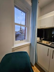 a kitchen with a window with a view of a church at Central Chambers Suites - Suite 4 in Leek +20 photos