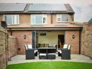 un patio con mesa y sillas frente a una casa en Shrewsbury Cottage, en Shrewsbury