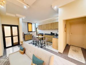 a living room and kitchen with a couch and a table at Ken-JResidence in Douala