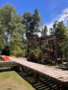 a wooden deck with a building in the background at Mostrotel - Tu Hotel en el Delta in Tigre