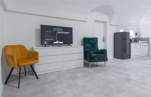 Una sala de estar con dos sillas y un televisor. en Apartments - Restart House Poprad, en Poprad