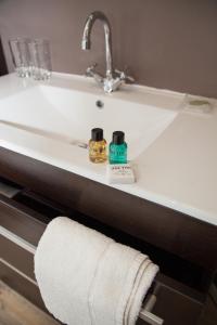 a bathroom sink with two bottles of soap and a towel at Trevor Arms in Wrexham