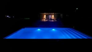 a swimming pool lit up in the dark at night at Casa quinta con pileta - Gardey in Gardey