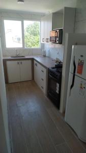 a small kitchen with a refrigerator and a sink at Alquiler Santa Clara del Mar calle Bilbao 4 personas in Santa Clara del Mar