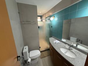 Un baño con inodoro, lavabo y espejo. en Lindo Apartamento em Cotovelo, en Parnamirim 6 fotos más