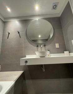a bathroom with a sink and a mirror at Edificio Libertador , Ushuaia in Ushuaia +10 photos