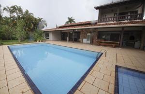 a large swimming pool in front of a house at Villa Verde casa espaçosa com piscina e área verde no Lago Norte Brasilia in Brasília