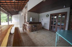 a living room with a table and a refrigerator at Villa Verde casa espaçosa com piscina e área verde no Lago Norte Brasilia in Brasília
