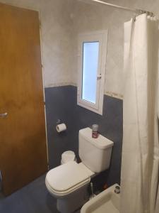 a bathroom with a toilet and a window at Sosiego Patagonico dpto A in Perito Moreno