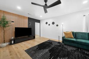 ein Wohnzimmer mit einem grünen Sofa und einem Flachbildfernseher in der Unterkunft Bakersfield Sunset Stay in Bakersfield