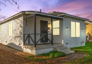 ein kleines weißes Haus mit einer Eingangstür in der Unterkunft Bakersfield Sunset Stay in Bakersfield