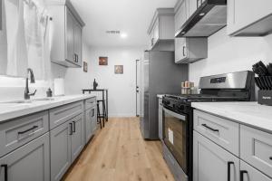 eine Küche mit Küchengeräten aus Edelstahl und Holzböden in der Unterkunft Bakersfield Sunset Stay in Bakersfield