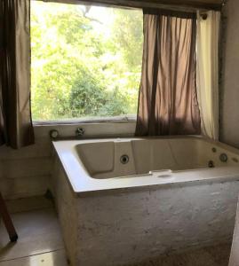 a bath tub in a bathroom with a window at Sitio Holistico Natureza Sanadora in Morro Reuter +94 photos